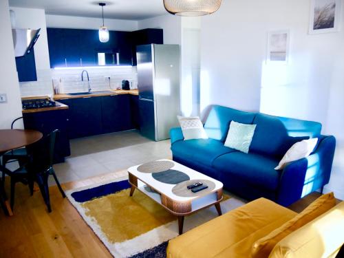 sala de estar con sofá azul y mesa en Horizon, en Le Plessis-Robinson