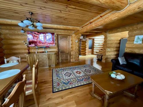 una baita di tronchi con soggiorno dotato di TV e tavolo di DADA Chalet - Vatra Dornei, Bucovina a Vatra Dornei