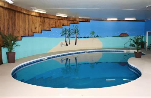 a large swimming pool in a building with a mural at Florenceville Inn, Restaurant & Pool in Florenceville