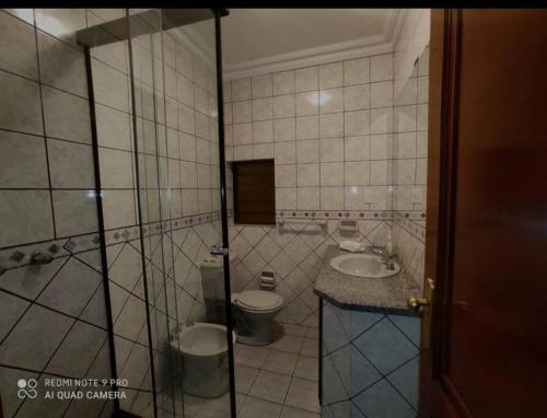 a tiled bathroom with a toilet and a sink at Departamento frente a Plaza Sucre, vista panorámica, 6 personas, 2 habitaciones, ascensor, garaje extra in Tarija