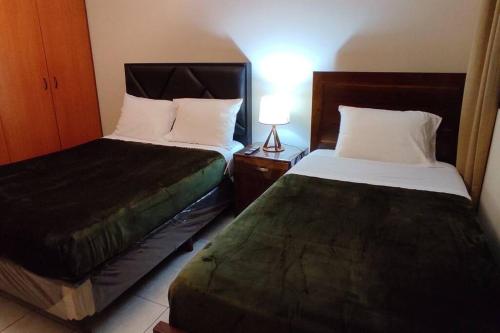 two beds in a hotel room with a bedskirts at Departamento frente a Plaza Sucre, vista panorámica, 6 personas, 2 habitaciones, ascensor, garaje extra in Tarija
