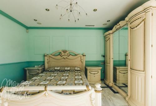 a bedroom with a bed with blue walls and a chandelier at Luxurious 5 Bedroom Apartment in Moncloa-Aravaca in Madrid