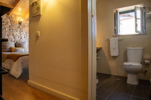 La salle de bains est pourvue de toilettes et d'un lit. dans l'établissement O Refúgio das Buracas, à Condeixa-a-Nova