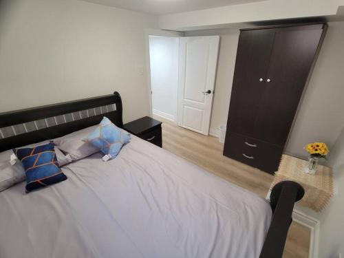 um quarto com uma cama grande e almofadas azuis em Basement apartment, 25 Minutes to Downtown em Toronto
