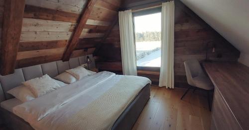 a bedroom with a bed and a window in a cabin at Willa Maciejka - Domek Narciarski in Trybsz