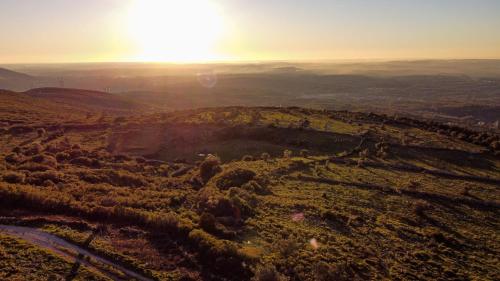 an aerial view of a field with the sun in the background at O Refúgio das Buracas in Condeixa a Nova