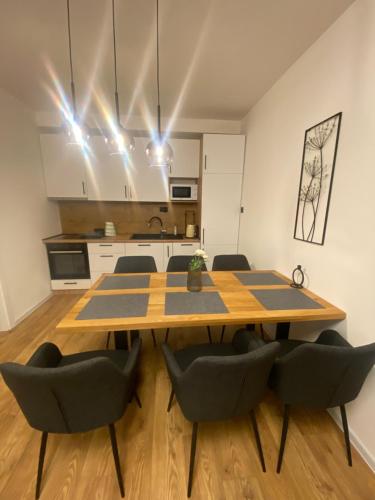 a dining room table with chairs and a kitchen at GO Jahorina by Olympic Gardens in Jahorina
