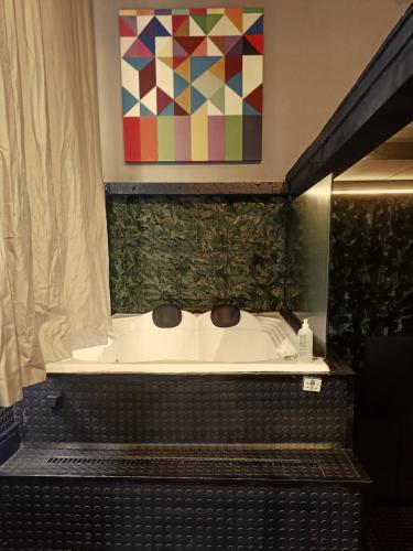 a bath tub in a bathroom with a painting on the wall at Loft Sagitárius - Central Zone - Lotk1 in Rio de Janeiro