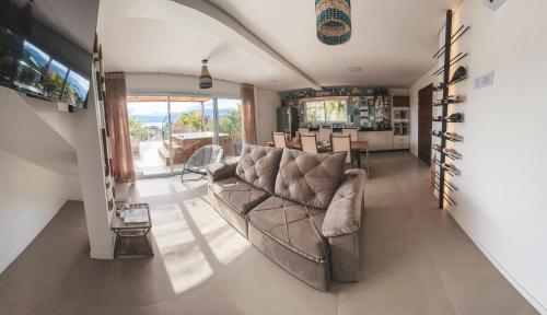 a living room with a couch and a table at Villa Verde Bangalô - Garopaba - SC in Garopaba