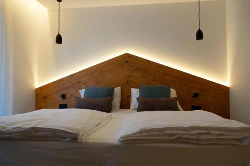 a bedroom with a large bed with a wooden headboard at Chalet Larix Andalo Deluxe Apartments in Andalo