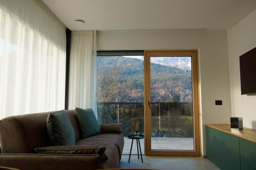 a living room with a couch and a sliding glass door at Chalet Larix Andalo Deluxe Apartments in Andalo