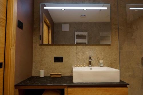 a bathroom with a white sink and a mirror at Chalet Larix Andalo Deluxe Apartments in Andalo