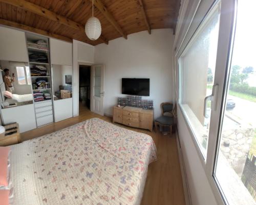 1 dormitorio con cama y ventana grande en Casa del parque en Necochea