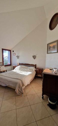 une chambre avec un grand lit et une table dans l'établissement Chez Marcelle et Claude, à Belleville-sur-Meuse