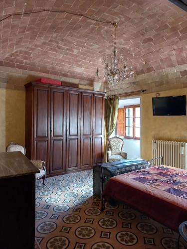 a bedroom with a bed and a chandelier at Casa Marzocco in Pomarance