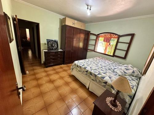 um quarto com uma cama e uma mesa com um candeeiro em Chácara Marretto, ambiente acolhedor e familiar dentro da cidade de Tatuí. em Tatuí