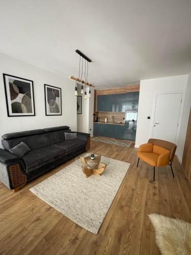 a living room with a black couch and a table at GO Jahorina by Olympic Gardens in Jahorina