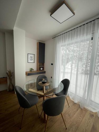 a dining room with a glass table and chairs at GO Jahorina by Olympic Gardens in Jahorina