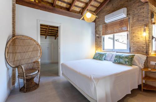 a bedroom with a bed and a rattan chair at Mediterranean Gem Getaway in Valencia