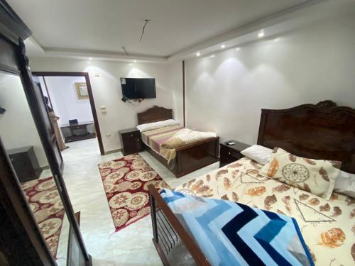Habitación pequeña con 2 camas y TV. en شقق فندقيه بمدينه المنصوره en Ṭalkha