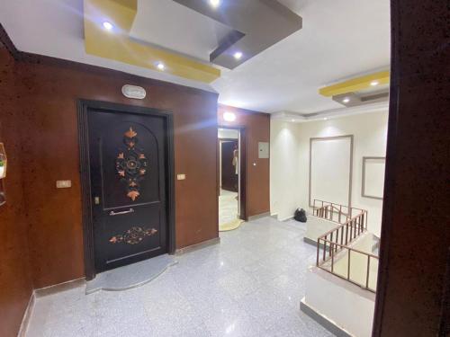 un pasillo con una gran puerta negra en un edificio en شقق فندقيه بمدينه المنصوره en Ṭalkha