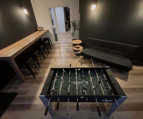 a ping pong table in the middle of a room at La Belle Excuse in Saint-Joachim