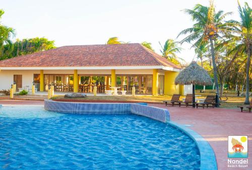 a house with a swimming pool in front of a house at Nandel Beach Resort in La Cruz