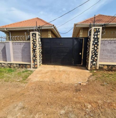 a black gate in front of a house at Tizo comfort homes in Wakiso