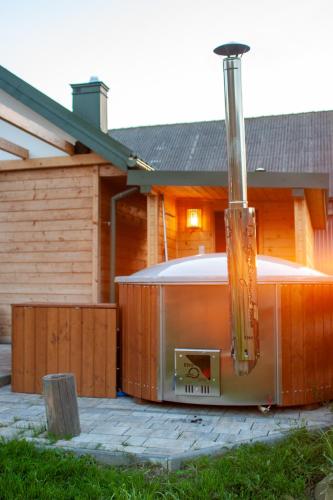 a hot tub in front of a house at Ranczo Molikówka gospodarstwo z Końmi Sauna i Banią in Siołkowa