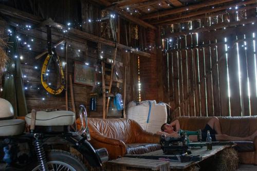 a man laying on a leather couch in a barn at Ranczo Molikówka gospodarstwo z Końmi Sauna i Banią in Siołkowa