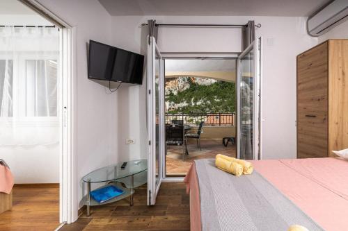 1 dormitorio con una puerta corredera de cristal que da a un balcón en Apartments Serzane, en Zastražišće