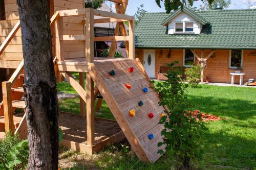 a wooden climbing ladder next to a tree at Ranczo Molikówka gospodarstwo z Końmi Sauna i Banią in Siołkowa