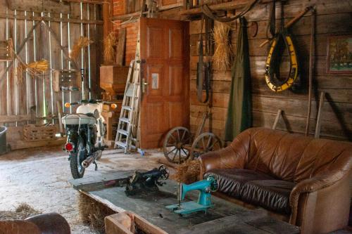 a living room with a couch and a motorcycle on a table at Ranczo Molikówka gospodarstwo z Końmi Sauna i Banią in Siołkowa