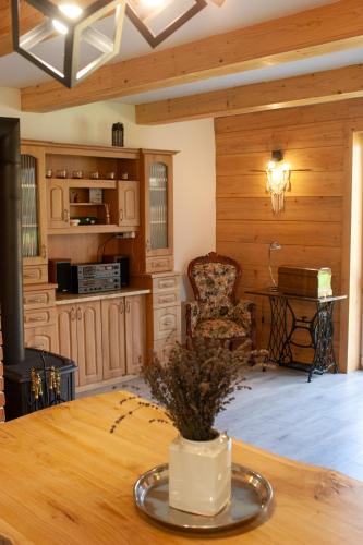 a living room with a table and a kitchen at Ranczo Molikówka gospodarstwo z Końmi Sauna i Banią in Siołkowa