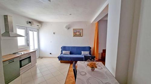 路巴奇的住宿－Apartments Poljubac，客厅配有蓝色的沙发和桌子