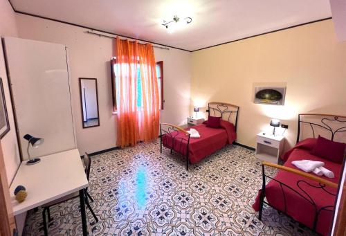 Cette chambre comprend deux lits et un canapé rouge. dans l'établissement Case vacanze Villa La Terrazza Sul Mare a Trabia, à Trabia