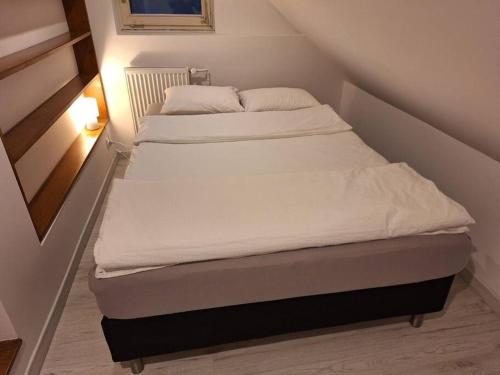 a bed in a small room with white sheets and pillows at Top Apartment in Bielsko-Biała