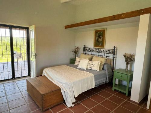 een slaapkamer met een bed en een groot raam bij La Lomita, Calamuchita, un plan de tranquilidad y naturaleza plena in Cordoba
