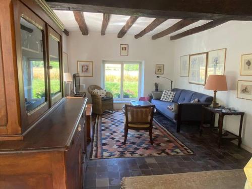a living room with a blue couch and a table at Jolie maison de campagne au bord d'un ruisseau in Vinon