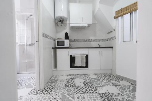 cocina con suelo de baldosa y microondas en Apartamento La Inmaculada, en Ayamonte