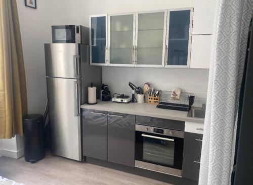 a kitchen with a stainless steel refrigerator and cabinets at Studio Vincennes centre in Vincennes