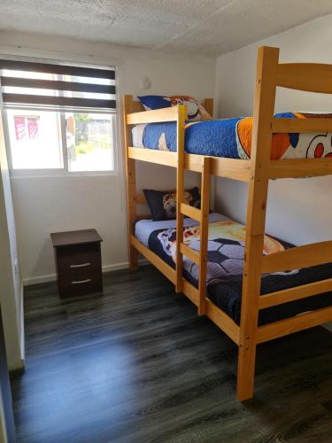a bedroom with two bunk beds and a window at departamento in Puerto Montt