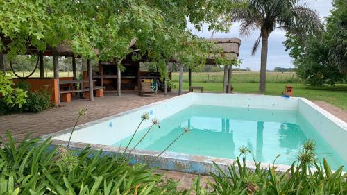 een groot zwembad in een tuin met een tafel bij Chacra Casa Quinta Carmen de Areco - La Alpargata in Carmen de Areco