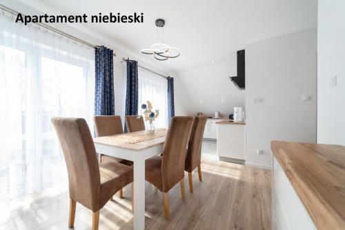 a dining room with a white table and chairs at Apartamenty i Pokoje Gościnne Willa Dawid in Jastarnia