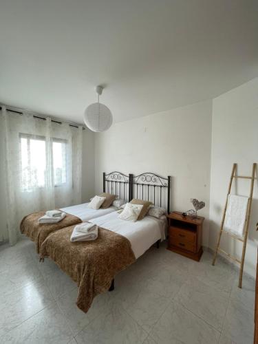 een slaapkamer met 2 bedden en een tafel en een lamp bij APARTAMENTO PURI in Candeleda
