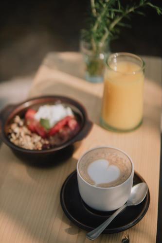 a table with a cup of coffee and a plate of food at ArtBau Designhotel in Waldkirch
