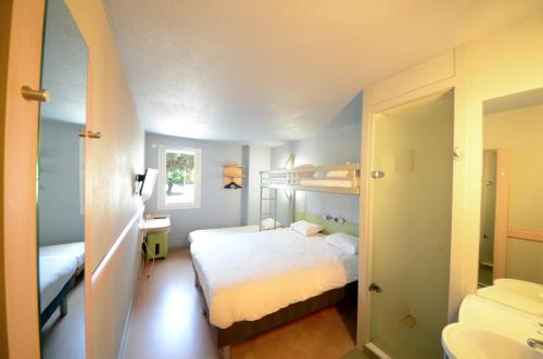 a bedroom with a bunk bed and a bathroom at ibis budget Brive La Gaillarde in Brive-la-Gaillarde