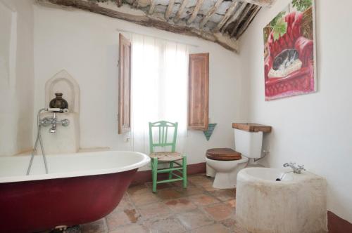 a bathroom with a bath tub and a toilet at Rural House, heated pool & steam room, Casa Aloe. in Atalbéitar