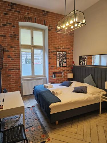 um quarto com uma cama e uma parede de tijolos em JUWEL Uroczy Apartament 2B Stare Miasto Kraków em Cracóvia