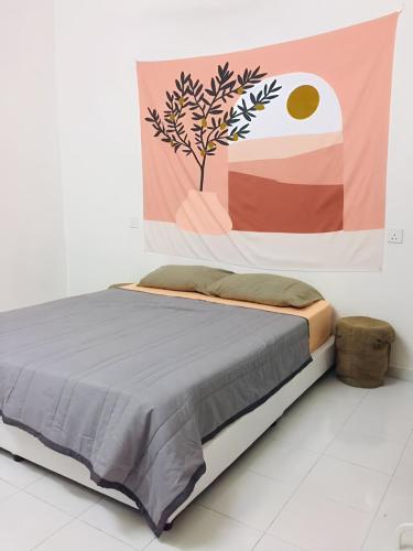 uma cama num quarto com uma pintura na parede em House By the Palms em Kampong Sungai Rambai